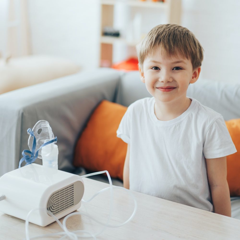 Little boy sitting on the couch in front of the nebulizer